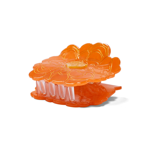 Side view of an hair clip in the shape of an orange marigold flower.